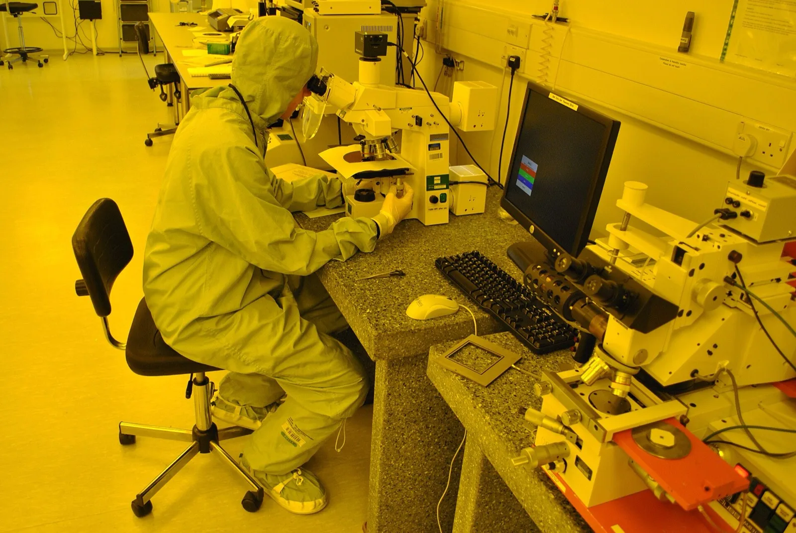 A semiconductor cleanroom photolithography lab under orange safe-lighting