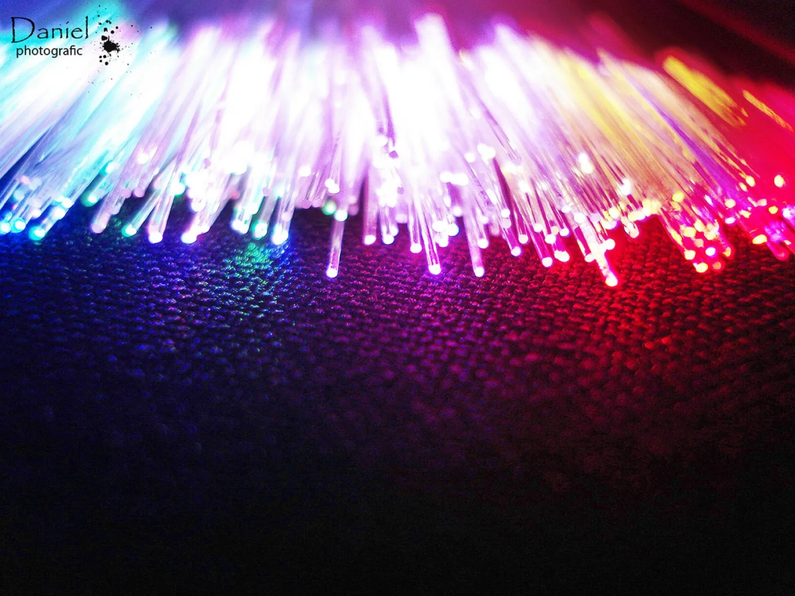 Glowing strands of colorful fiber-optic cable in close-up