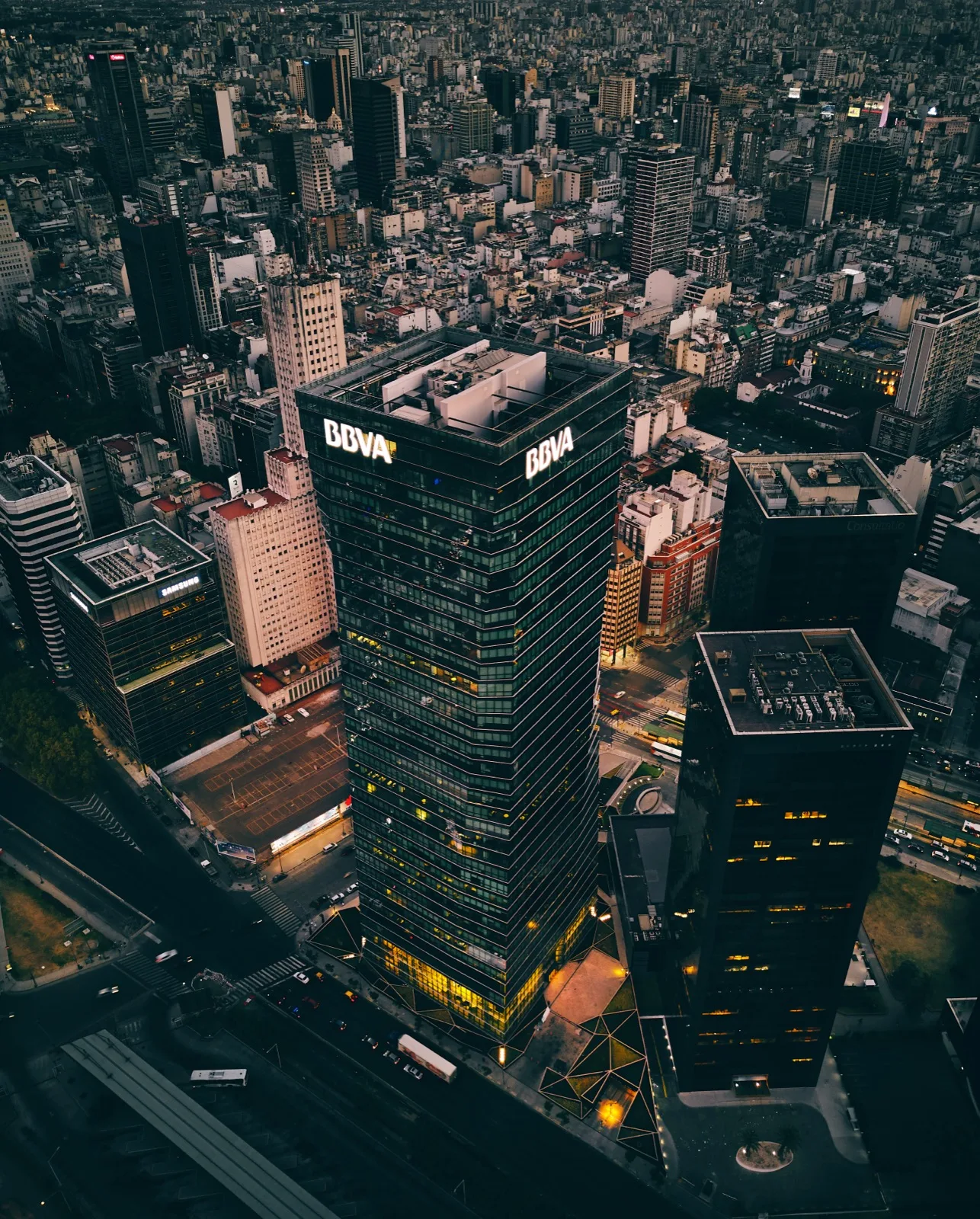 Pantalla con cotizaciones bursátiles y el edificio de la Bolsa de Comercio de Buenos Aires de fondo