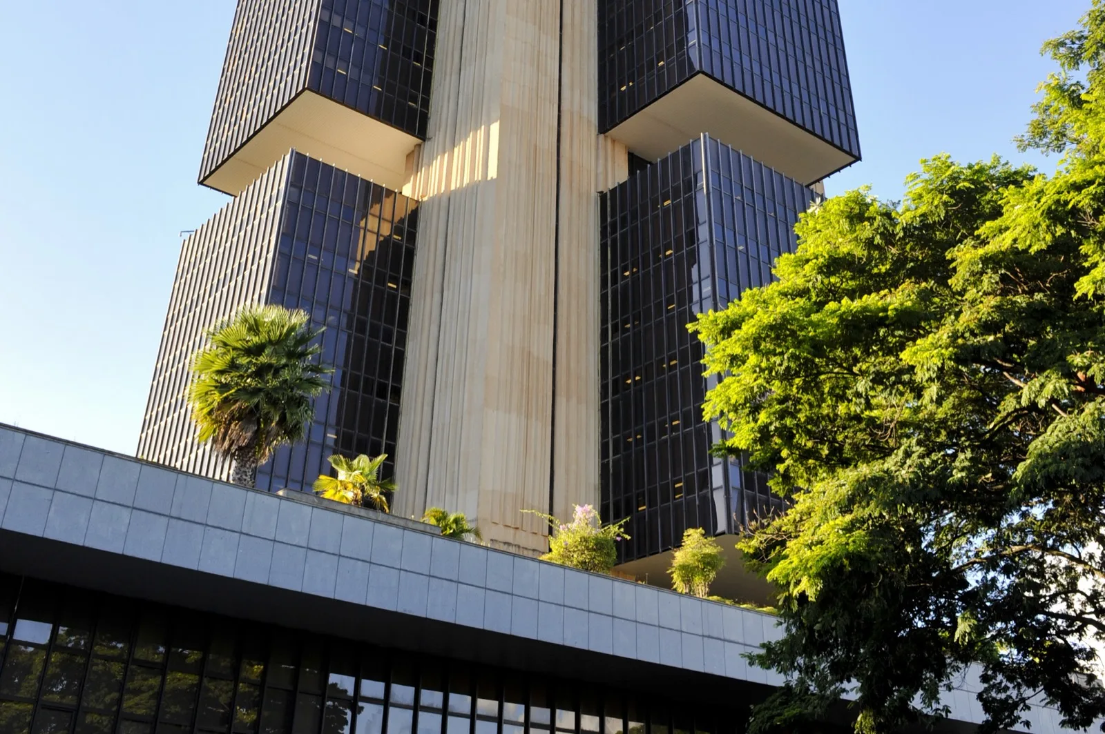 Fachada da bolsa de valores B3 em São Paulo, com o letreiro da bolsa e o movimento de pedestres em frente ao edifício