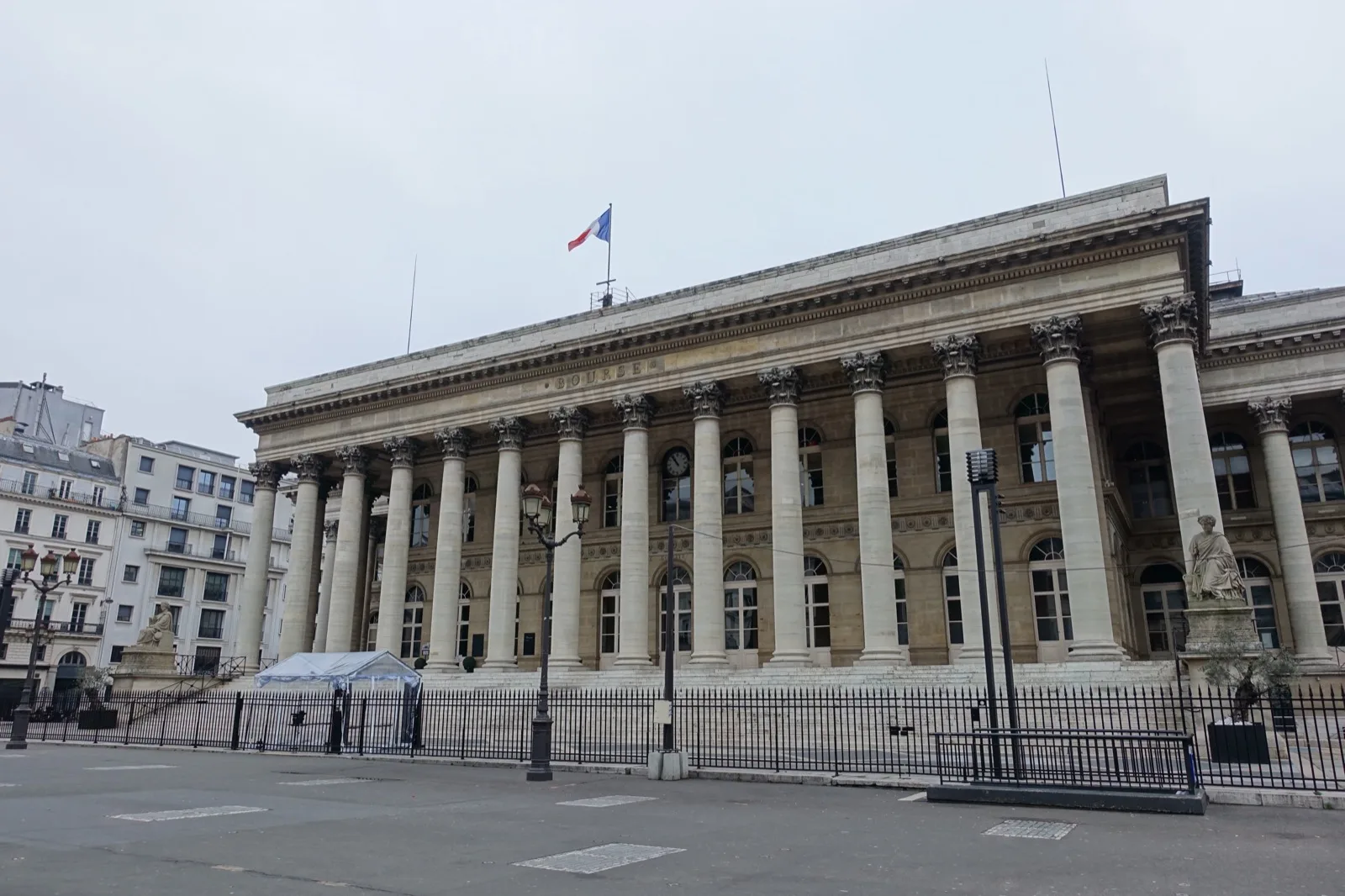 Gros plan sur un graphique financier et des documents relatifs à une émission obligataire sur un bureau, avec un ordinateur portable affichant des courbes de marché