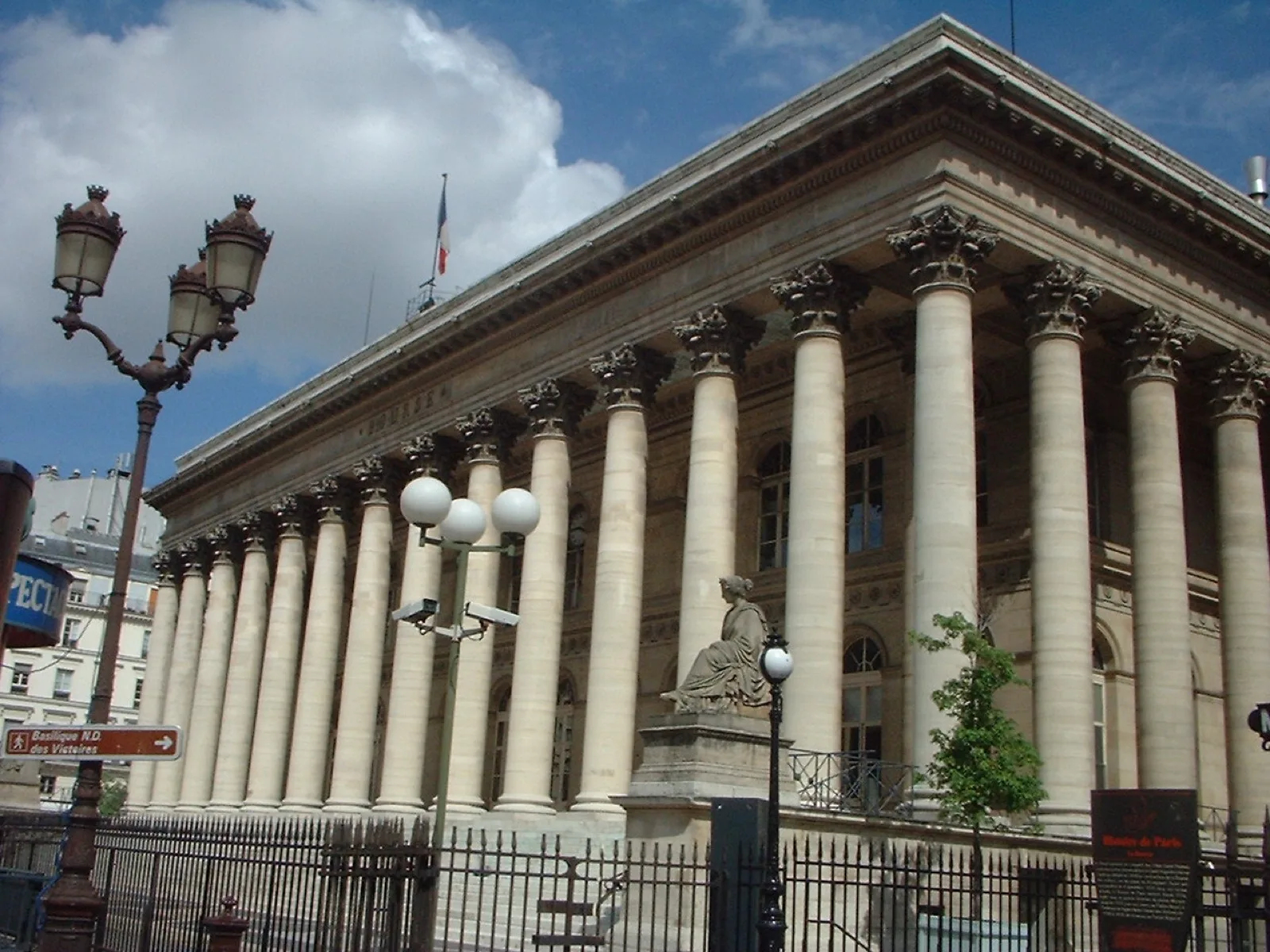 Gros plan sur un graphique financier et des documents relatifs à une émission obligataire sur un bureau, avec un ordinateur portable affichant des courbes de marché