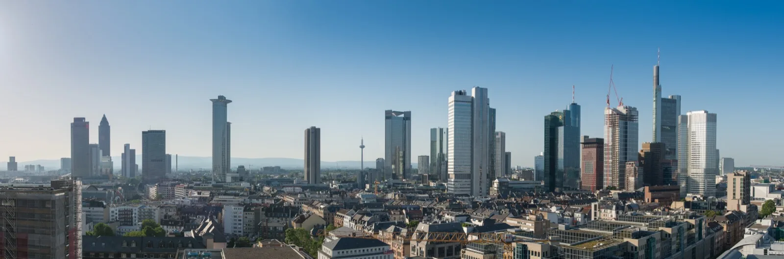Ein Börsenhändler betrachtet mehrere Bildschirme mit Kurscharts und Finanzkennzahlen in einem Handelsraum