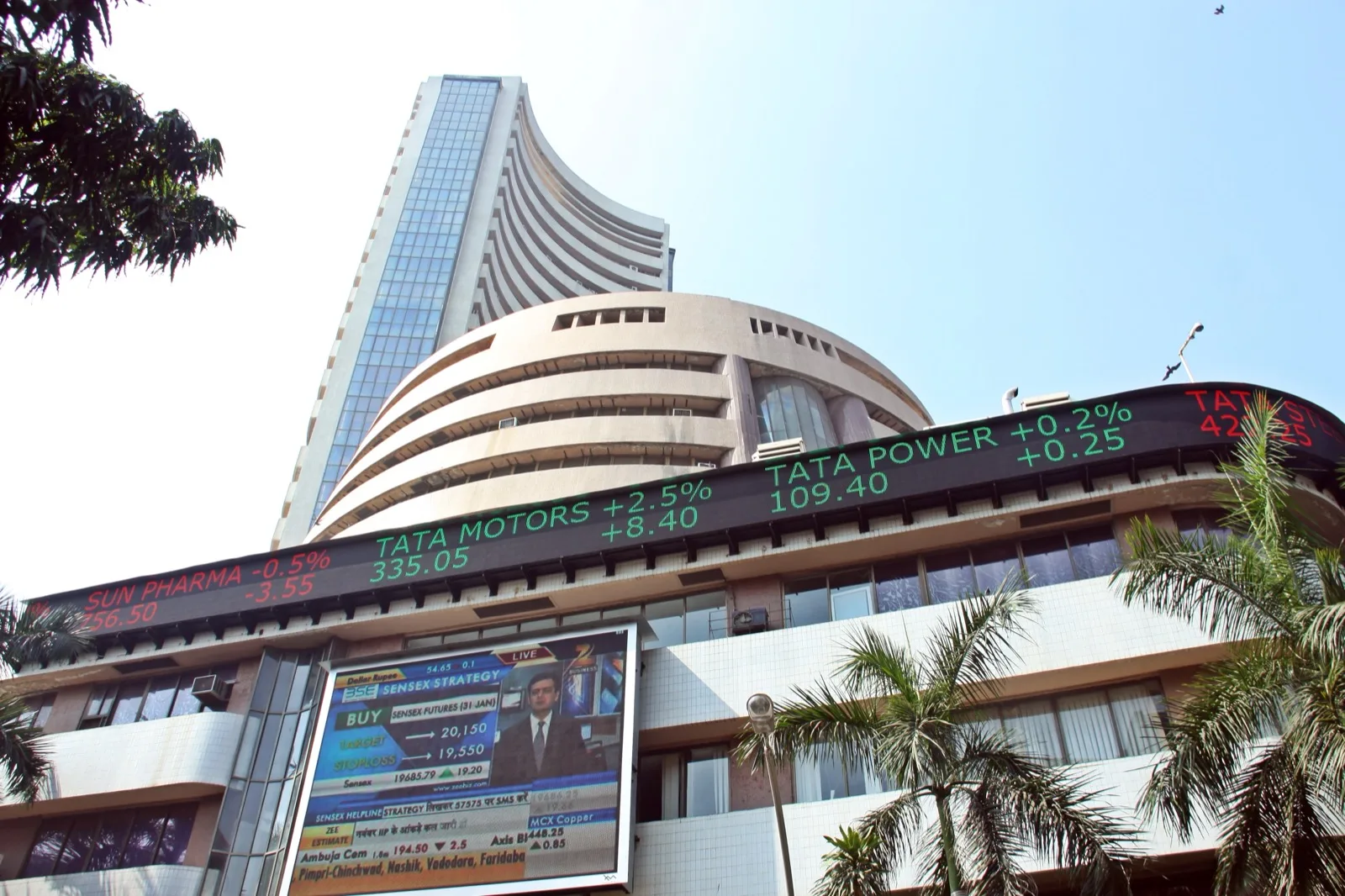 A digital stock ticker board displaying rows of share prices and percentage changes at an Indian stock exchange