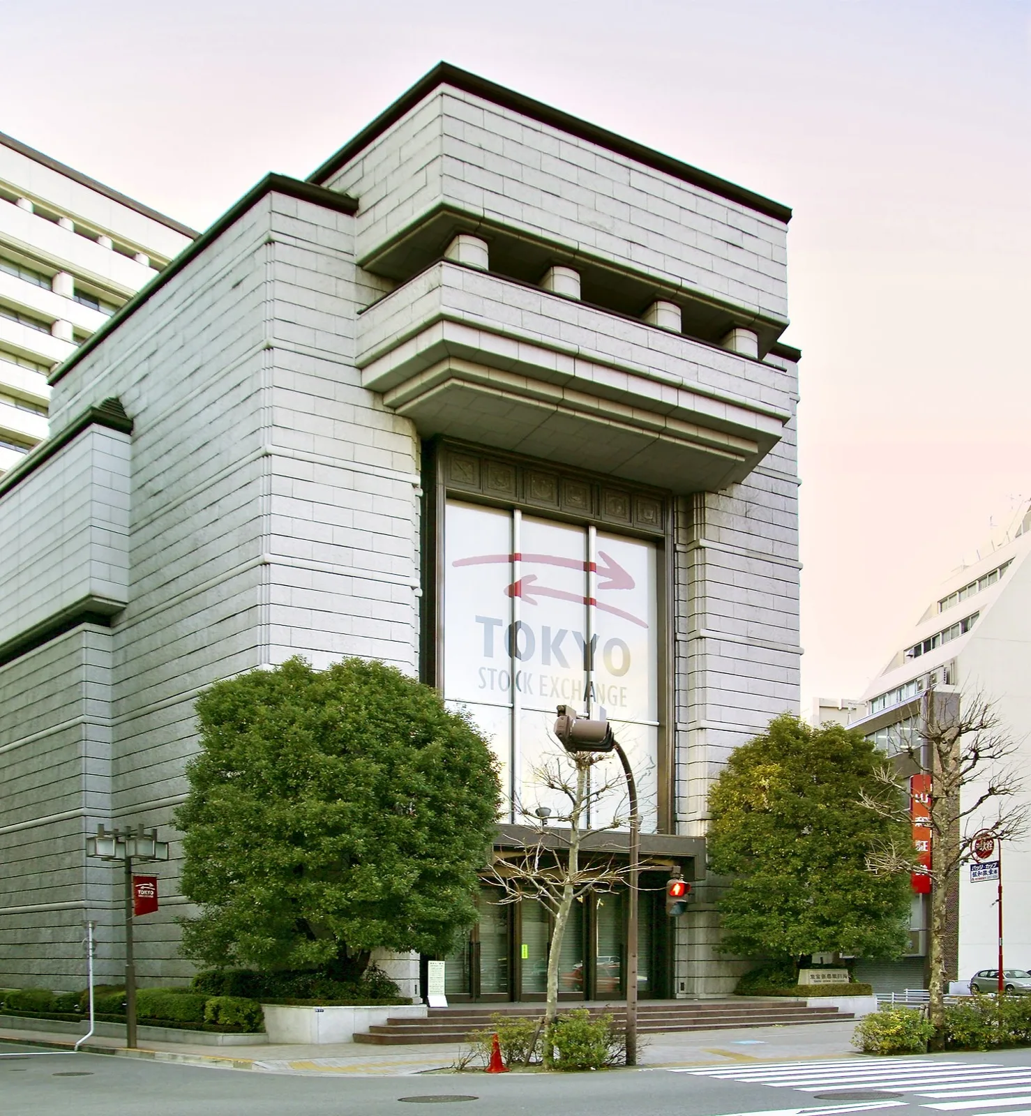 証券取引所の電光掲示板に表示される株価と配当関連の数値を見つめる投資家たち