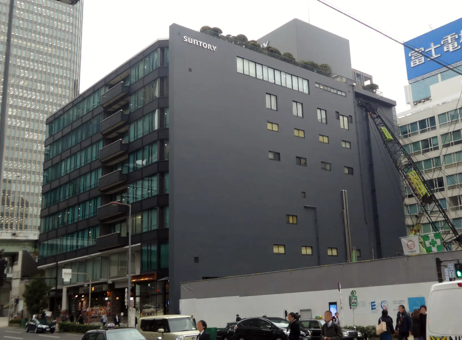 東京証券取引所の建物外観と、周辺を行き交うビジネスパーソンを写した写真