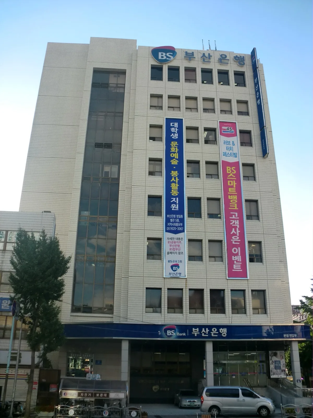 Exterior view of the Korea Exchange building in Busan, South Korea, with its glass facade reflecting the sky
