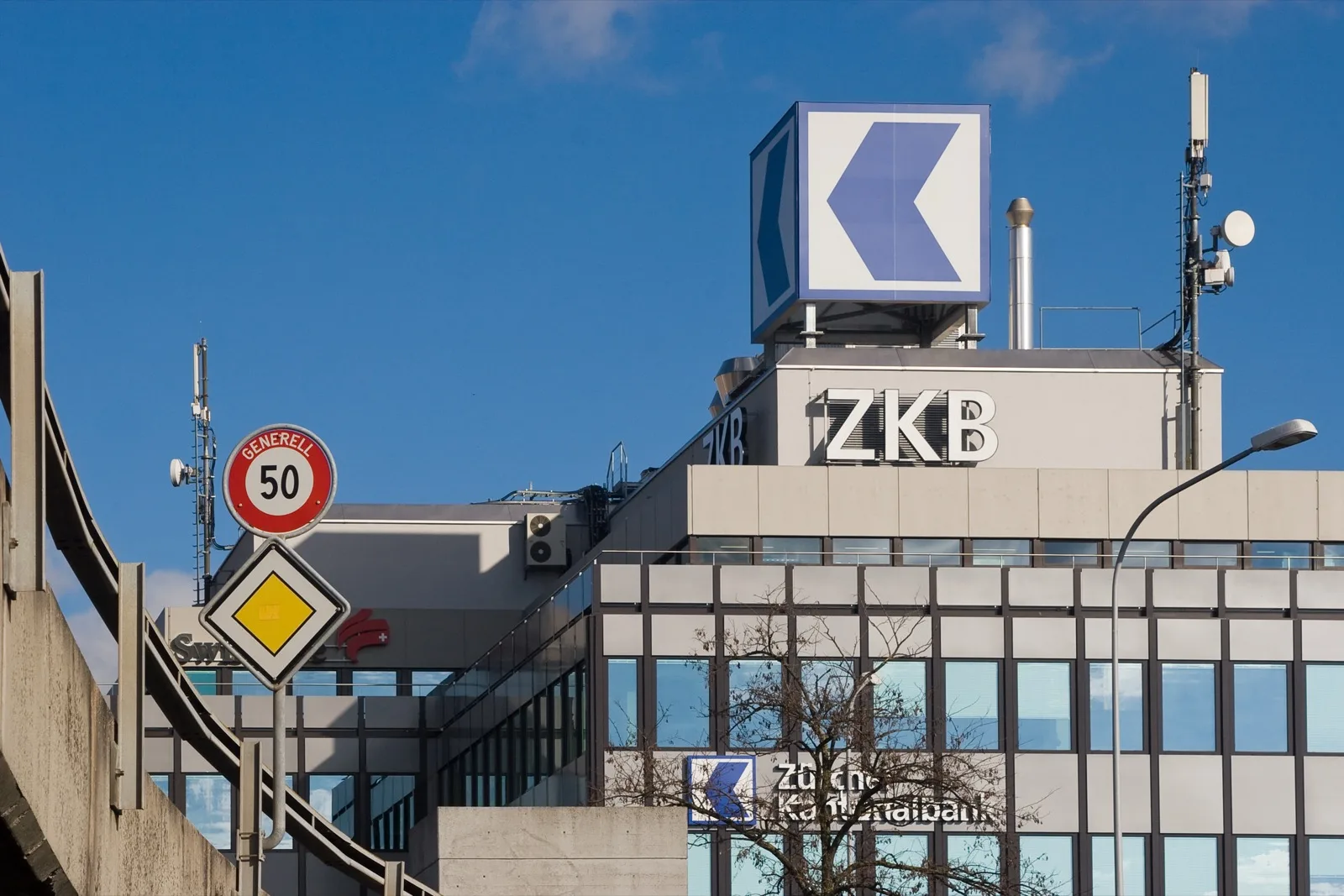 Fassade und Eingangsbereich der SIX Swiss Exchange in Zürich mit Schweizer Flaggen