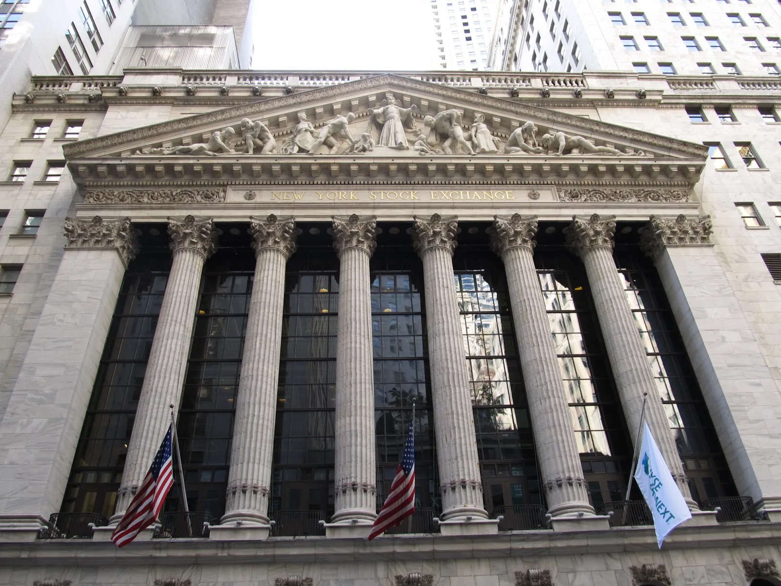 A stock exchange trading floor display board showing scrolling ticker symbols and price changes